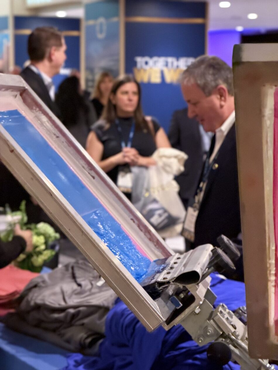 Close-up of a live station tool mid-demonstration with formally dressed guests watching